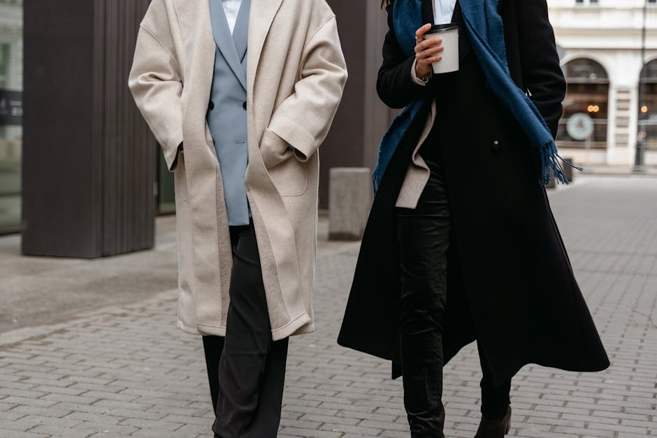 People walking on a city street in winter wearing coats, one person holding a coffee cup People walking on a city street in winter wearing coats, one person holding a coffee cup